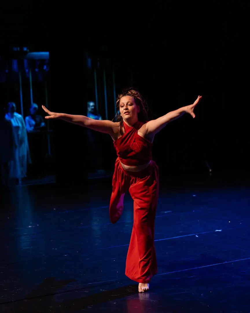 Pauline sur scène, en rouge, bras ouverts